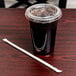 A plastic cup with a lid and a green and white Eco-Products straw next to it.
