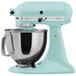 A blue KitchenAid Artisan mixer with a bowl on top.