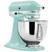 A white KitchenAid tilt-head countertop mixer in aqua with a bowl attached.