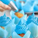 A close up of a cupcake with blue swirls on top using Chefmaster Neon Brite Blue Liqua-Gel Food Coloring.