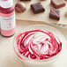 A bowl of red and white swirls with pink chocolate drizzle using Chefmaster Pink Oil-Based Candy Color.