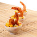 A group of white Fineline Tiny Temptations bowls with shrimp and pineapple.