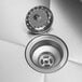A close-up of the drain on a Regency stainless steel 2 compartment sink.