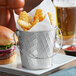 A Tablecraft lattice stainless steel serving pail filled with fries and a burger on a table.