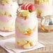 A dessert in an Acopa Rustic Charm mason jar with a strawberry on top.