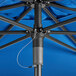 A close up of a blue Lancaster Table & Seating umbrella on an outdoor table.