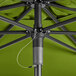 A Lancaster Table & Seating moss green umbrella with a black metal pole.