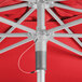 A close up of the top of a red metal Lancaster Table & Seating umbrella.