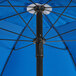 A blue Lancaster Table & Seating umbrella with a black pole.