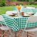 A table set up outside with a green and white checkered vinyl table cover on it.