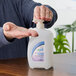 A person holding a Kutol Health Guard alcohol hand sanitizer pump bottle.