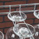 A Regency chrome wire bar glass rack holding wine glasses.