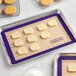 A tray of cookies on a Baker's Mark purple silicone baking mat.