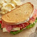 A sandwich made with Amoroso's Rustic Pane bread with meat, cheese, and chips.