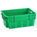 A green plastic vented agricultural crate with handles and holes.