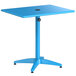 A blue Lancaster Table & Seating outdoor table with a black metal base and an umbrella hole.