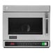An Amana stainless steel commercial microwave with a black door open.