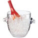 A Cal-Mil clear polycarbonate ice bucket with a wine bottle in it surrounded by ice.