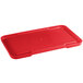 A red plastic recessed lid for a meat lug on a white table.