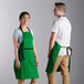 A man and woman wearing Kelly green Choice restaurant aprons with black accents.