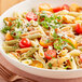 A bowl of Barilla tri-color penne pasta with tomatoes and basil.