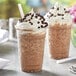 Two cups of Capora Java Chip Frappes with whipped cream and chocolate chips.