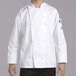 A man wearing a white Chef Revival long sleeve chef jacket with cloth knot buttons.