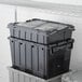 A stack of black Choice Small Stackable Chafer Totes with lids.