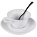 A white cup and saucer with a spoon in it.
