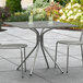 A Lancaster Table & Seating gray outdoor table with modern legs on a patio.