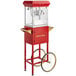 A red Carnival King popcorn popper machine with a cart.