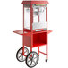 A red Carnival King popcorn machine on a cart with wheels.