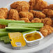 A plate of chicken nuggets and cucumbers with a container of Heinz Honey Mustard.