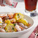 A bowl of shrimp and corn with TABASCO&#174; Original Hot Sauce on the table.