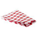 A folded red and white checkered vinyl table cover.