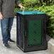 A man standing next to a black and green Cerobin recycling and compost container.