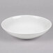 A white Reserve by Libbey porcelain coupe bowl on a gray surface.