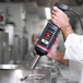 A chef using a Sammic XM-33 hand blender in a professional kitchen.