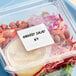 A plastic container with a Noble Products removable blank label on a salad in it.