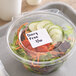 A salad in a plastic container with a Noble Products permanent blank label on it.