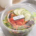A plastic container of vegetables with a Noble Products Permanent Hospital label on the counter.