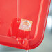 A red plastic tray with a Noble Products Saturday food label on a piece of paper.