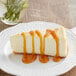 A slice of cheesecake with Capora Salted Caramel Flavoring Sauce on a white plate.