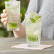 Two Duralex highball glasses of water with ice and mint leaves.