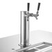 A Beverage-Air kegerator with four silver metal taps and black handles on a counter.
