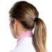 A woman wearing a light pink Intedge chef neckerchief with her hair in a ponytail.