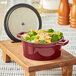 A Valor merlot enameled cast iron pot with pasta and broccoli on a wood tray.