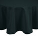A hunter green round tablecloth with a hemmed edge on a table.