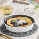 A Valor Arctic White enameled cast iron skillet with blueberries and cream.