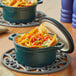 A Valor Bistro Green enameled cast iron pot filled with nachos with vegetables.